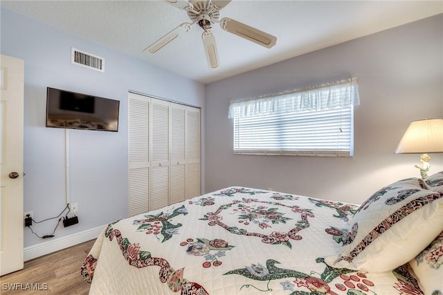 bedroom with hardwood / wood-style floors, a closet, and ceiling fan