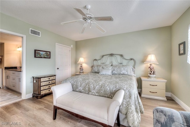 bedroom with ceiling fan, ensuite bathroom, and light hardwood / wood-style floors