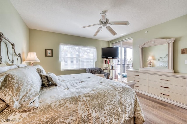 bedroom with ceiling fan, access to outside, light hardwood / wood-style floors, and a textured ceiling