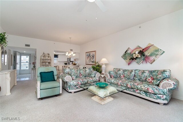 living room featuring light colored carpet and ceiling fan with notable chandelier