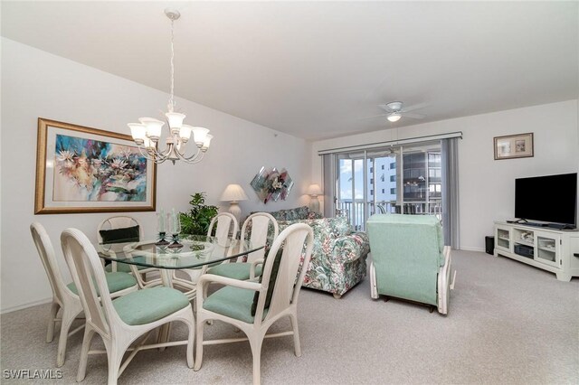 carpeted dining room with ceiling fan with notable chandelier