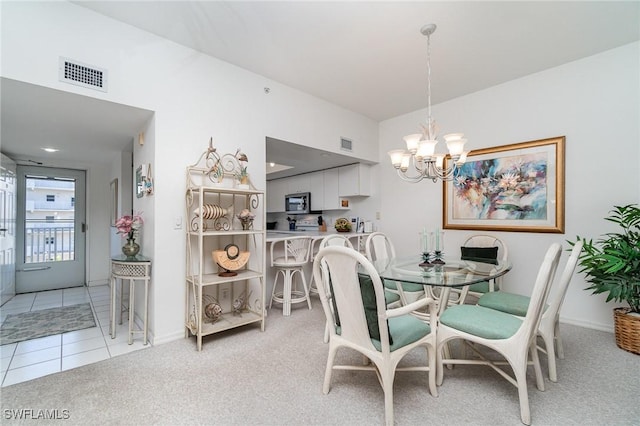 carpeted dining space with a notable chandelier