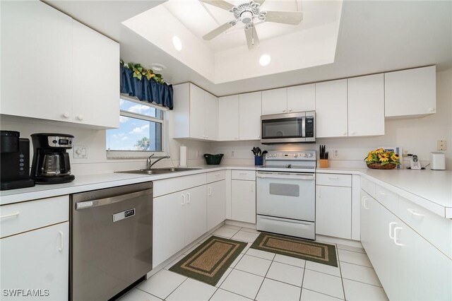 kitchen with sink, white cabinetry, a raised ceiling, ceiling fan, and stainless steel appliances