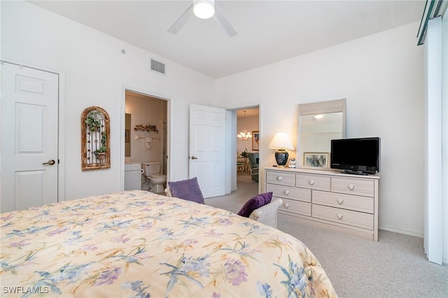 bedroom with ensuite bathroom, ceiling fan with notable chandelier, and light colored carpet