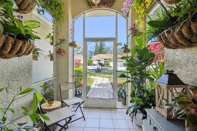 doorway to outside featuring light tile patterned flooring and a healthy amount of sunlight