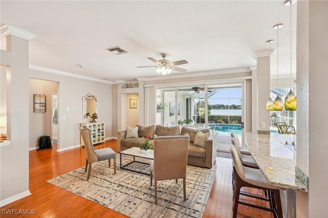 living room featuring ornamental molding, ceiling fan, and light wood-type flooring