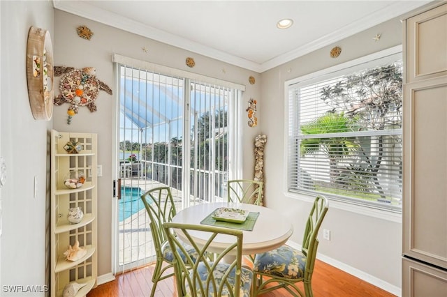 dining space with hardwood / wood-style flooring and crown molding