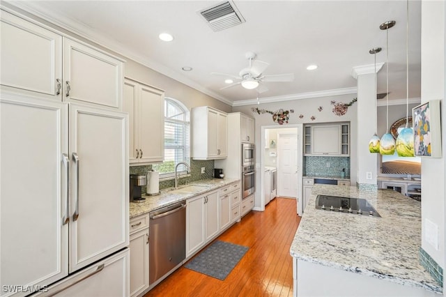 kitchen with decorative light fixtures, sink, decorative backsplash, ornamental molding, and stainless steel appliances