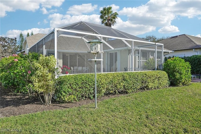 rear view of house featuring a yard and a lanai