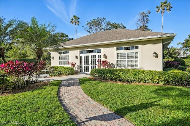 rear view of house featuring a yard and french doors