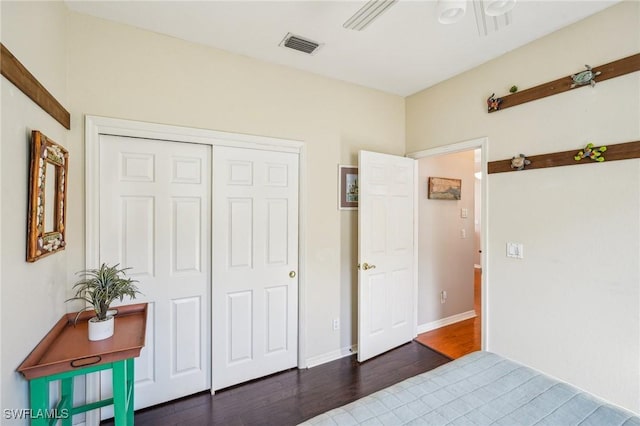 bedroom featuring dark hardwood / wood-style flooring, a closet, and ceiling fan