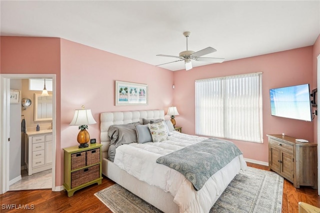 bedroom with ensuite bathroom, light wood-type flooring, and ceiling fan