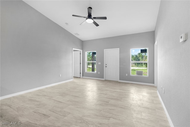 empty room featuring ceiling fan, plenty of natural light, and high vaulted ceiling