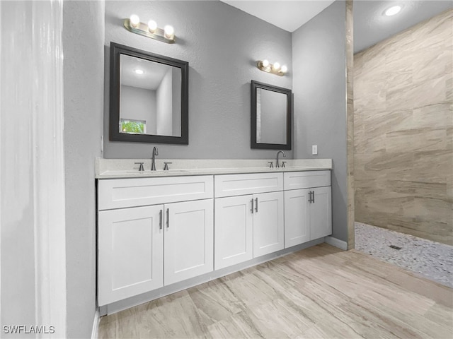 bathroom featuring a shower and vanity