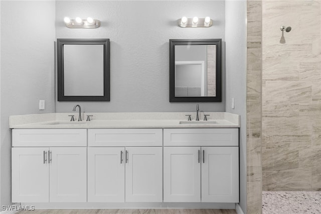 bathroom featuring a shower and vanity