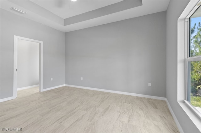 unfurnished room with a tray ceiling