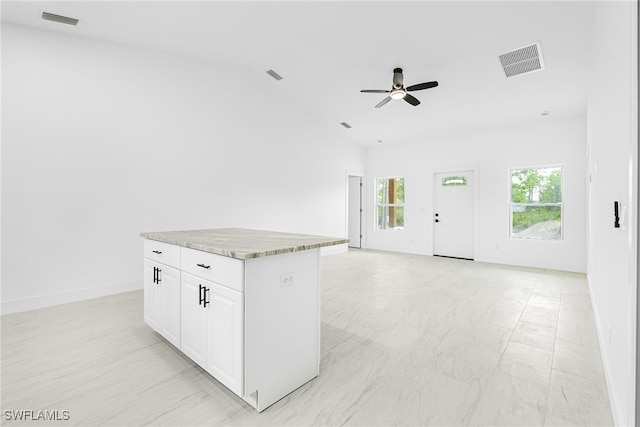 27141 Alhambra Dr, Punta Gorda, FL 33955 - kitchen featuring a ceiling fan, vaulted ceiling, white cabinets, a center island, and light countertops