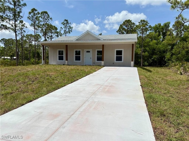 27141 Alhambra Dr, Punta Gorda, FL 33955 - view of front of property featuring driveway, a front yard, and board and batten siding