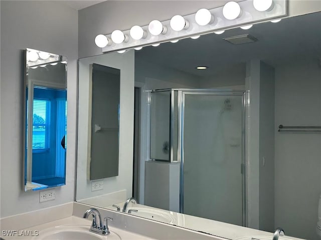 bathroom featuring toilet, vanity, and a shower with shower door