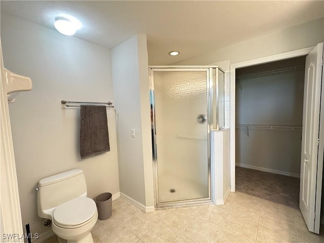 bathroom with tile patterned floors, toilet, and a shower with shower door