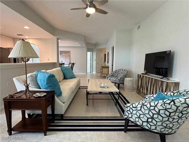 tiled living room with ceiling fan