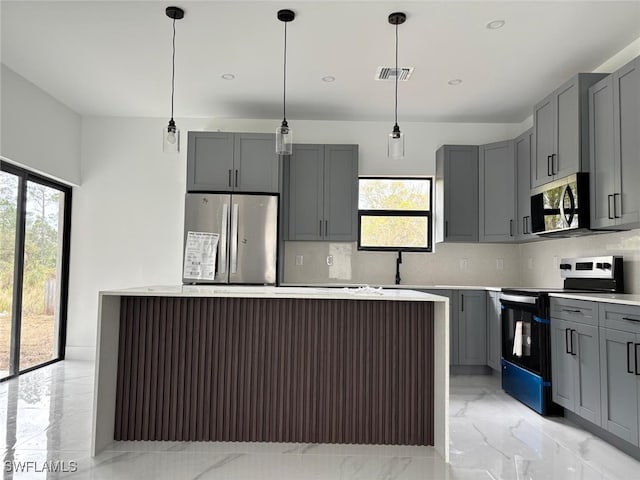 kitchen with stainless steel appliances, a kitchen island, a healthy amount of sunlight, and gray cabinetry