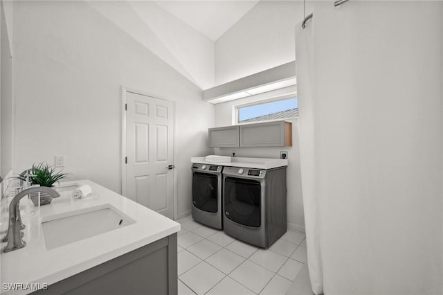 laundry room featuring light tile patterned floors, washing machine and dryer, sink, and cabinets