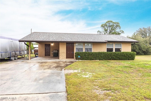 single story home featuring a front lawn and a carport