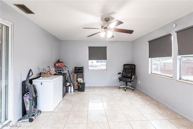 clothes washing area with ceiling fan and light tile patterned floors