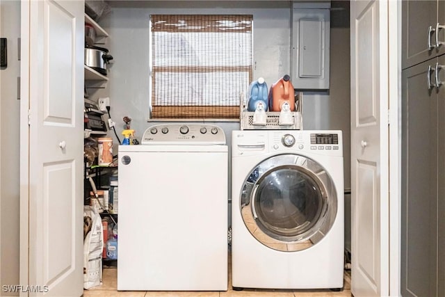 laundry area featuring light tile patterned flooring, electric panel, and independent washer and dryer