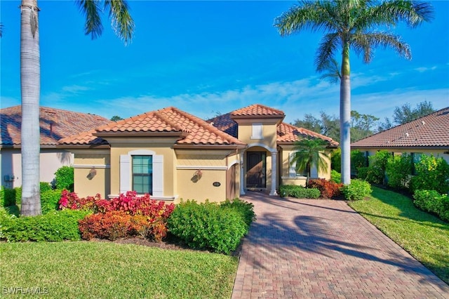 mediterranean / spanish-style house with a garage and a front lawn