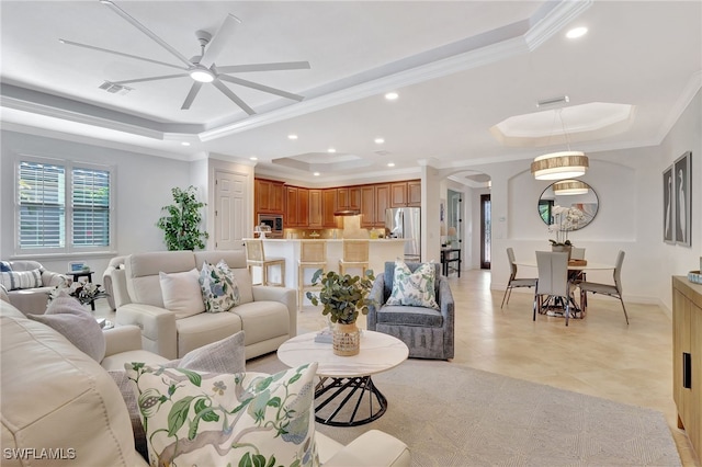 living room featuring a raised ceiling and ornamental molding