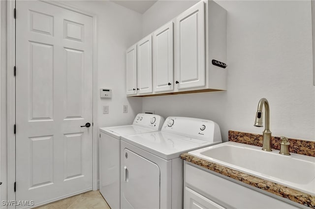 laundry room with sink, light tile patterned floors, cabinets, and washing machine and clothes dryer