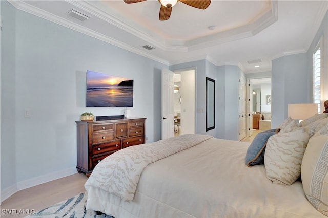 bedroom featuring ensuite bathroom, light wood-type flooring, ornamental molding, a raised ceiling, and ceiling fan