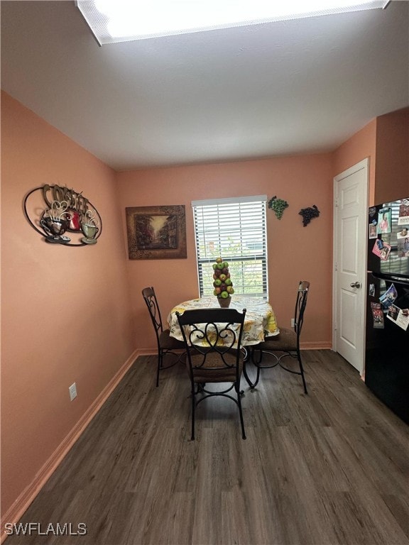 dining area with dark hardwood / wood-style flooring