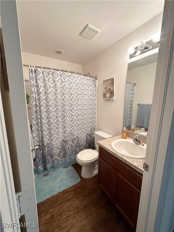 bathroom featuring toilet, hardwood / wood-style floors, and vanity