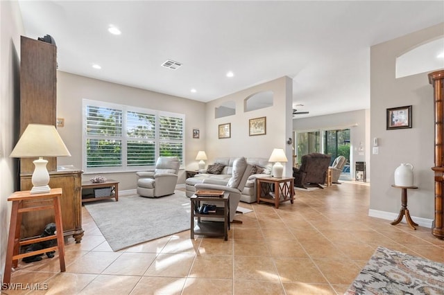 tiled living room with ceiling fan and a healthy amount of sunlight