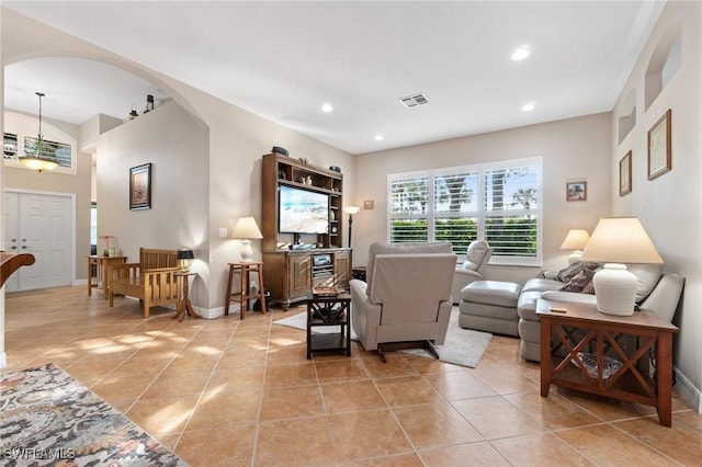 living room featuring arched walkways, light tile patterned floors, recessed lighting, visible vents, and baseboards