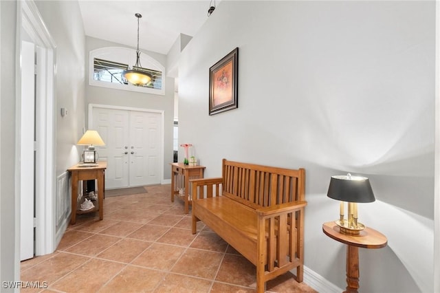 foyer featuring a towering ceiling, baseboards, and tile patterned floors