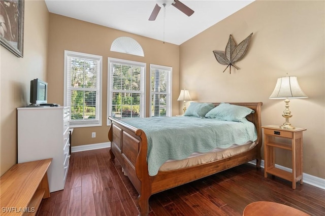 bedroom with dark wood finished floors, a ceiling fan, and baseboards