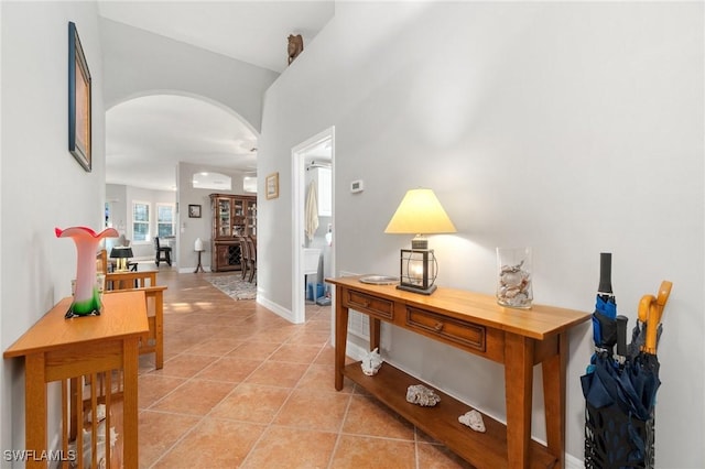 hall with an AC wall unit and light tile patterned floors