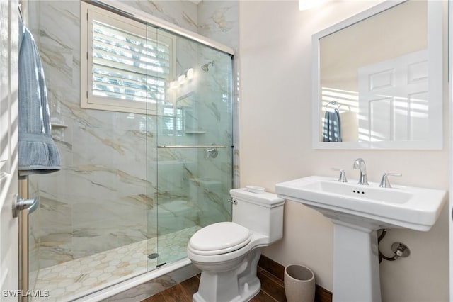 full bath featuring a marble finish shower, toilet, and wood finished floors