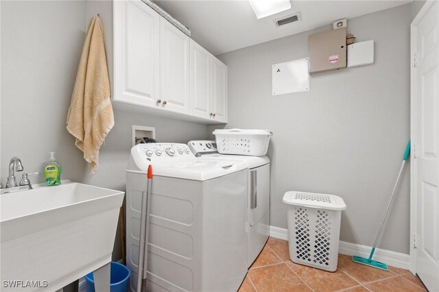 laundry area featuring sink, cabinets, washer and dryer, and light tile patterned flooring