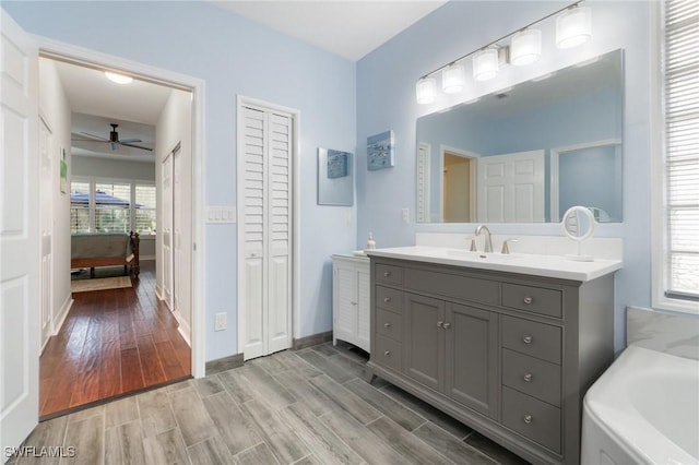 bathroom with a wealth of natural light, vanity, a closet, and wood finish floors