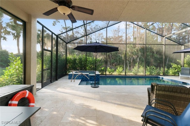 pool with a patio area, glass enclosure, and an in ground hot tub