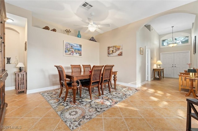 dining room with light tile patterned floors, a towering ceiling, and ceiling fan