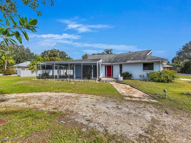 view of front of property featuring a front yard and a sunroom