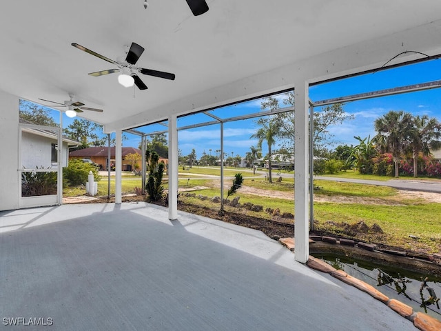 unfurnished sunroom featuring ceiling fan and a wealth of natural light