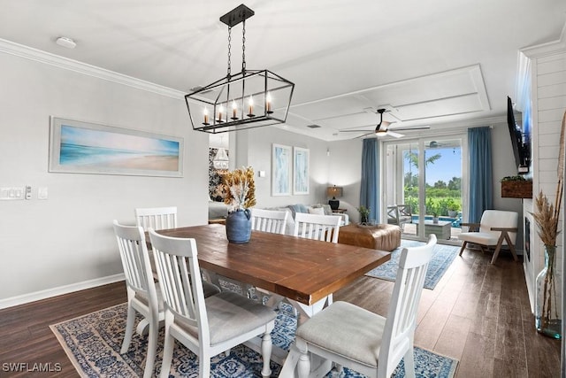 dining space featuring dark wood-type flooring, crown molding, and ceiling fan with notable chandelier