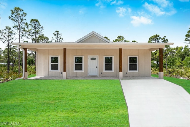 27159 Alhambra Dr, Punta Gorda, FL 33955 - view of front of home featuring board and batten siding, a front lawn, and a patio area